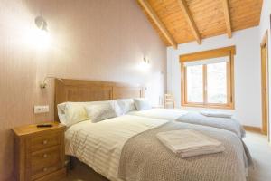 Schlafzimmer mit einem Bett mit einem Kopfteil aus Holz und einem Fenster in der Unterkunft Casa da Ponte de Penas in Melide + 73 Fotos