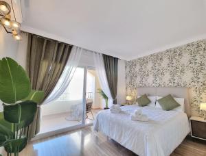 um quarto com uma cama branca e uma grande janela em Luxury Hacienda Playa em Marbella
