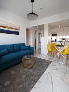 ein Wohnzimmer mit einem blauen Sofa und gelben Stühlen in der Unterkunft Arilvia good vibes only in Costa Calma