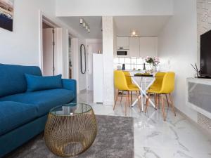 ein Wohnzimmer mit einem blauen Sofa und gelben Stühlen in der Unterkunft Arilvia good vibes only in Costa Calma