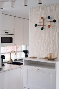 eine Küche mit weißen Schränken und geometrischen Tapeten in der Unterkunft Arilvia good vibes only in Costa Calma