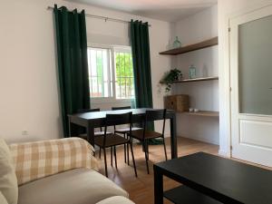 ein Wohnzimmer mit Tisch und Couch in der Unterkunft Casa Amapola - Costa Bahía de Cádiz in Puerto Real