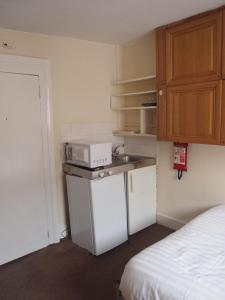 a small kitchen with a sink and a microwave at Paddington Flats in London