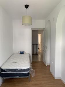 a white room with a bed and a hallway at Casa Amapola - Costa Bahía de Cádiz in Puerto Real