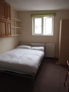 2 camas en una habitación pequeña con ventana en Paddington Flats en Londres