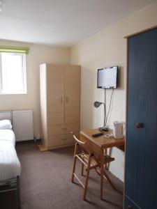 a hotel room with a desk and a bed and a bedroom at Paddington Flats in London