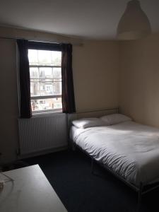 ロンドンにあるパディントン フラッツの窓付きの小さな部屋のベッド2台