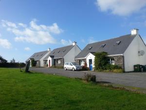 a row of houses with a car parked in the driveway at Portmagee Seaside Cottages in Portmagee