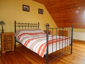Cama en habitación con techo de madera en Portmagee Seaside Cottages en Portmagee