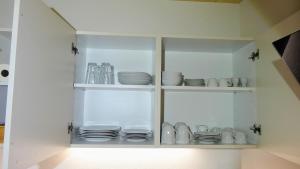 a white cabinet filled with plates and dishes at BachLauf im Happy Allgäu in Leutkirch im Allgäu