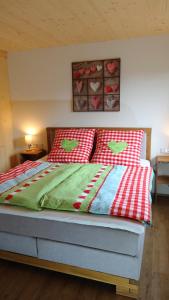 a bed with red and white blankets and pillows at BachLauf im Happy Allgäu in Leutkirch im Allgäu