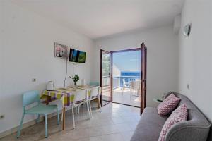 a living room with a table and a view of the ocean at Apartmani Pipin - Prigradica, kod Caffe Tempera in Prigradica