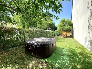 une grande poubelle noire assise dans l'herbe dans l'établissement Baleni House, à Amboise
