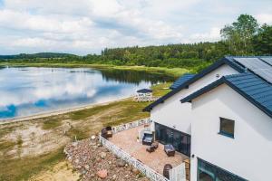 an aerial view of a house next to a lake at Płaczewo in Starogard Gdański