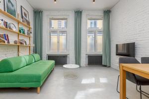 a living room with a green couch and a tv at Krásny byt v historickom centre Bratislavy in Bratislava