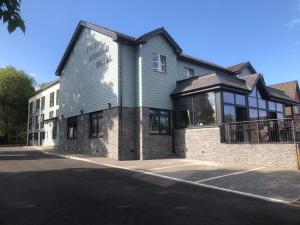 ein großes Gebäude mit Glasfenstern auf einer Straße in der Unterkunft Loch Lomond Hotel in Balloch