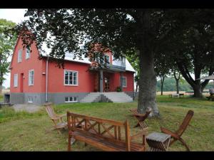 un groupe de bancs devant un bâtiment rouge dans l'établissement Stora Topphem, à Skåne-Tranås