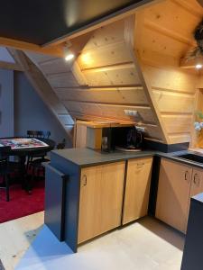 an attic kitchen with wooden ceilings and a table at APARTAMENT GLICZARÓWKA in Gliczarów