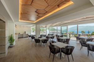 a dining room with tables and chairs and windows at Centar Novi in Herceg-Novi