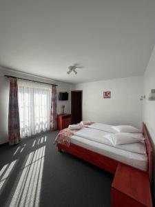 a bedroom with a large bed and a window at Pensiunea Casa Brancovenilor in Sâmbăta de Sus