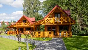 a large wooden house with a pathway in front of it at Domki nad jeziorem Kolonia Rybacka in Kolonia Rybacka