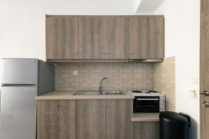 a kitchen with wooden cabinets and a sink and a refrigerator at Independent studio with yard in Bali
