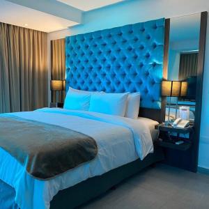Tibisay Hotel Boutique Margarita في بورلامار: غرفة نوم زرقاء مع سرير كبير مع اللوح الأمامي الأزرق