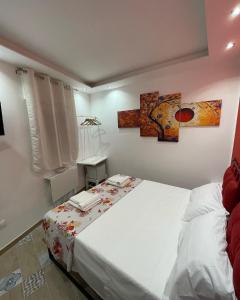 Un dormitorio con una gran cama blanca y una ventana en Red moon, en Margherita di Savoia