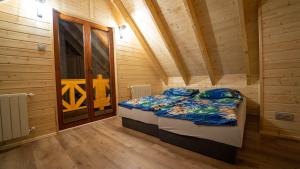 ein Schlafzimmer mit einem Bett in einer Holzhütte in der Unterkunft Domki nad jeziorem Kolonia Rybacka in Kolonia Rybacka