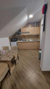 a room with a table and chairs and a kitchen at Apartment Slap in Rakovica