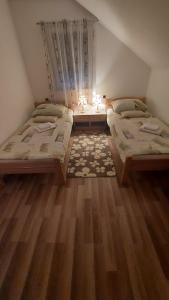 a bedroom with two beds and a table with a window at Apartment Slap in Rakovica