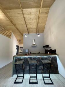 a room with a bar with three chairs and a table at Dili guest house in Dilijan