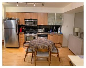 a kitchen with a table and chairs and a refrigerator at Cozy Condo in Centre of Downtown Toronto in Toronto