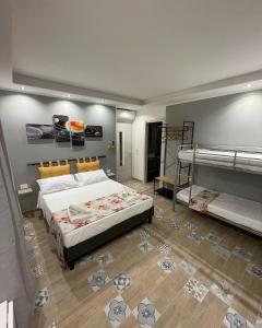 1 dormitorio con 1 cama y 2 literas en Red moon, en Margherita di Savoia