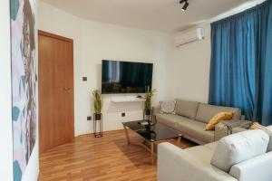 a living room with a couch and a tv at Luxury Art 4 Apartment in Blagoevgrad