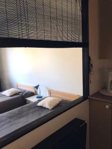 2 camas en una habitación con ventana en Saunallinen yksiö Jäppilässä, en Jäppilä