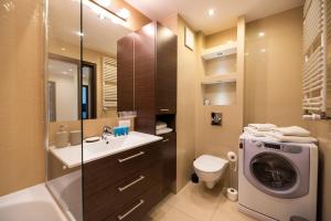 łazienka z umywalką i pralką w obiekcie Metro Kondratowicza Spacious Apartment w Warszawie