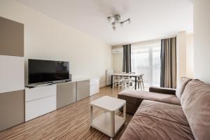 salon z kanapą, telewizorem i stołem w obiekcie Metro Kondratowicza Spacious Apartment w Warszawie