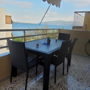 stół i krzesła na balkonie z widokiem na ocean w obiekcie SOFICOS Sea View Apartment w mieście Nafpaktos