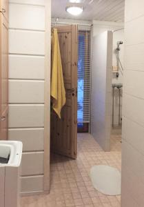 a bathroom with a wooden door and a sink at Holiday Cabin Kerimaa 90 in Kerimäki