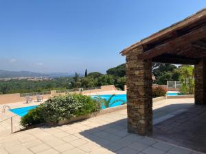 uma vista para uma piscina com um edifício de tijolos em Appartement vue mer golfe de Saint-Tropez em Cogolin