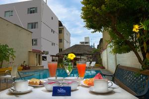 un tavolo con cibo e bevande accanto a una piscina di La Siesta Hotel a Santa Cruz de la Sierra