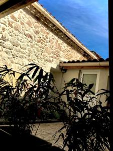 una casa de ladrillo con una ventana y una planta en Les couleurs de Balaruc Les Bains en Balaruc-les-Bains