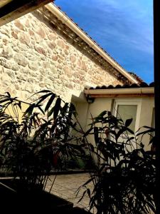 a brick house with a window and a plant at Les couleurs de Balaruc Les Bains in Balaruc-les-Bains
