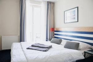 - une chambre avec un lit blanc et des serviettes dans l'établissement FeWo im maritimen Flair - 100m zu Strand & Seebrücke, à Zingst