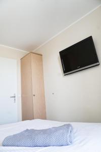 1 dormitorio con TV de pantalla plana en la pared en FeWo im maritimen Flair - 100m zu Strand & Seebrücke, en Zingst