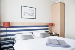 - une chambre avec un lit blanc aux rayures bleues et blanches dans l'établissement FeWo im maritimen Flair - 100m zu Strand & Seebrücke, à Zingst