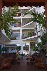 a building with chairs and plants in a courtyard at La Siesta Hotel in Santa Cruz de la Sierra