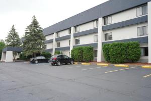 a building with two cars parked in a parking lot at Baymont by Wyndham Bridgeport/Frankenmuth in Bridgeport