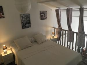 バラリュック・レ・バンにあるLes couleurs de Balaruc Les Bainsのベッドルーム1室(ベッド1台付)が備わります。壁に2枚の写真が飾られています。